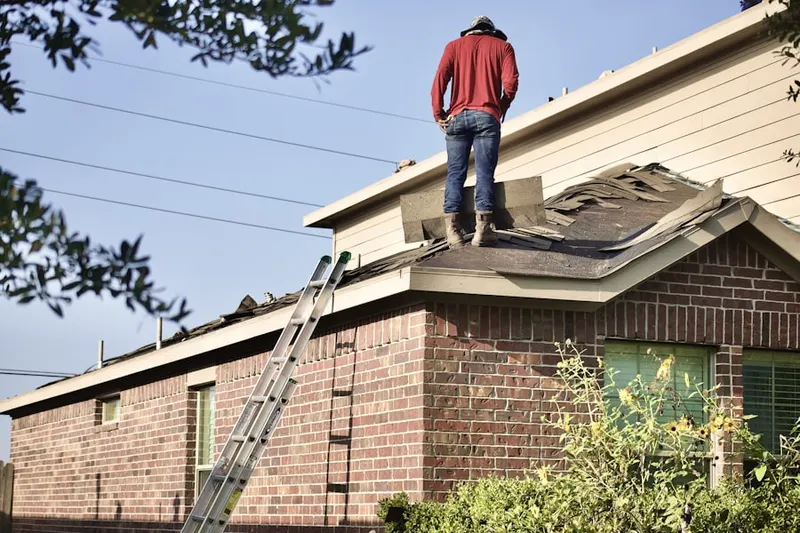 Professional roofer working on a residential roof in Elbridge